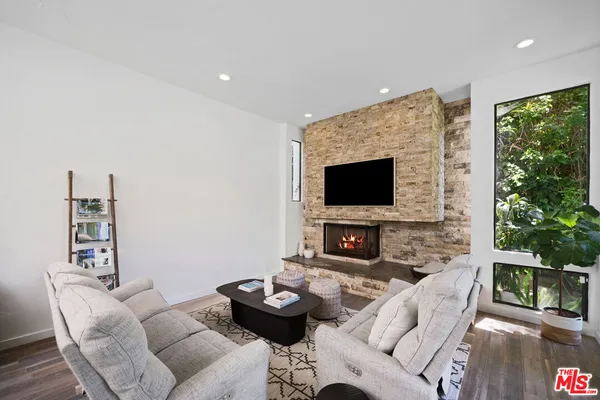 a living room with furniture a flat screen tv and a fireplace