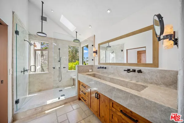 a spacious bathroom with a granite countertop tub sink shower and mirror