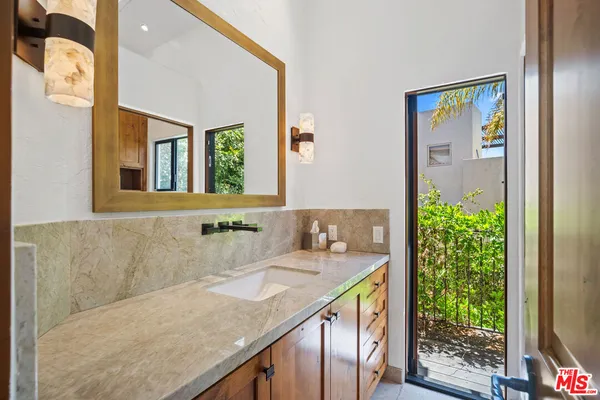 a bathroom with a granite countertop sink and a mirror