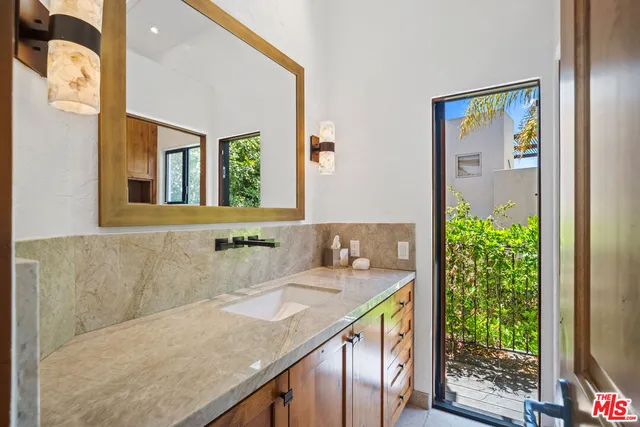 a bathroom with a granite countertop sink and a mirror