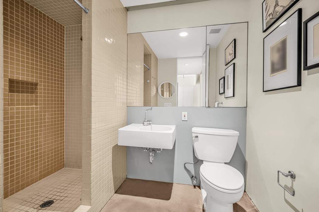 11 West 30th Street, Unit 8F Manhattan, NY 10001 - Photo 14 of 20 a white toilet sitting next to a bathroom sink