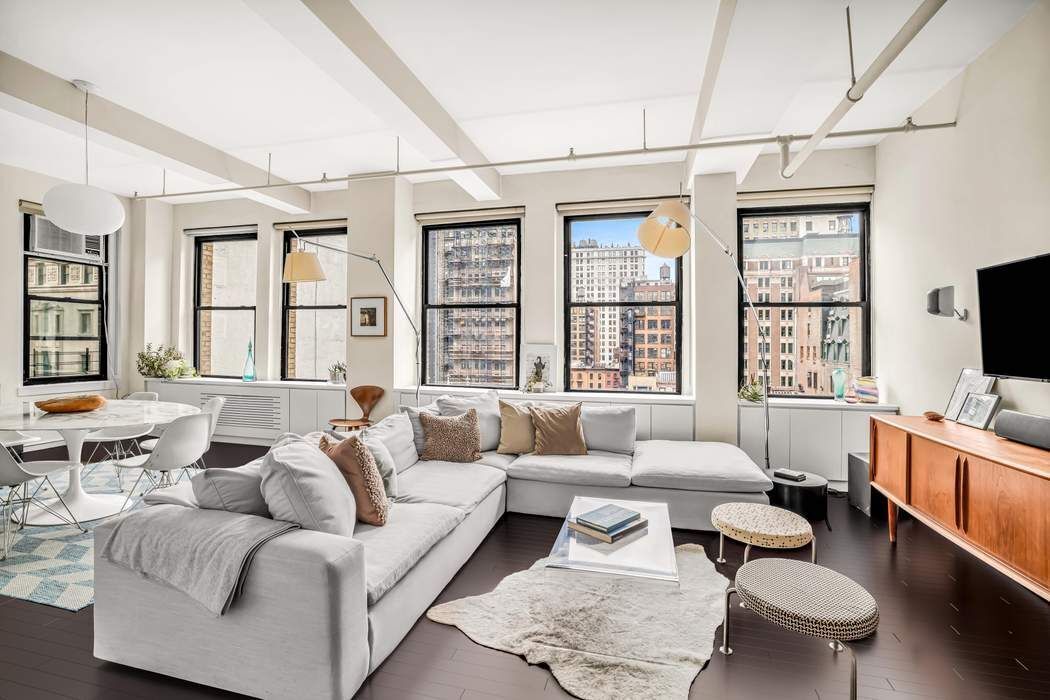 11 West 30th Street, Unit 8F Manhattan, NY 10001 - Photo 3 of 20 a living room with furniture a flat screen tv and a large window