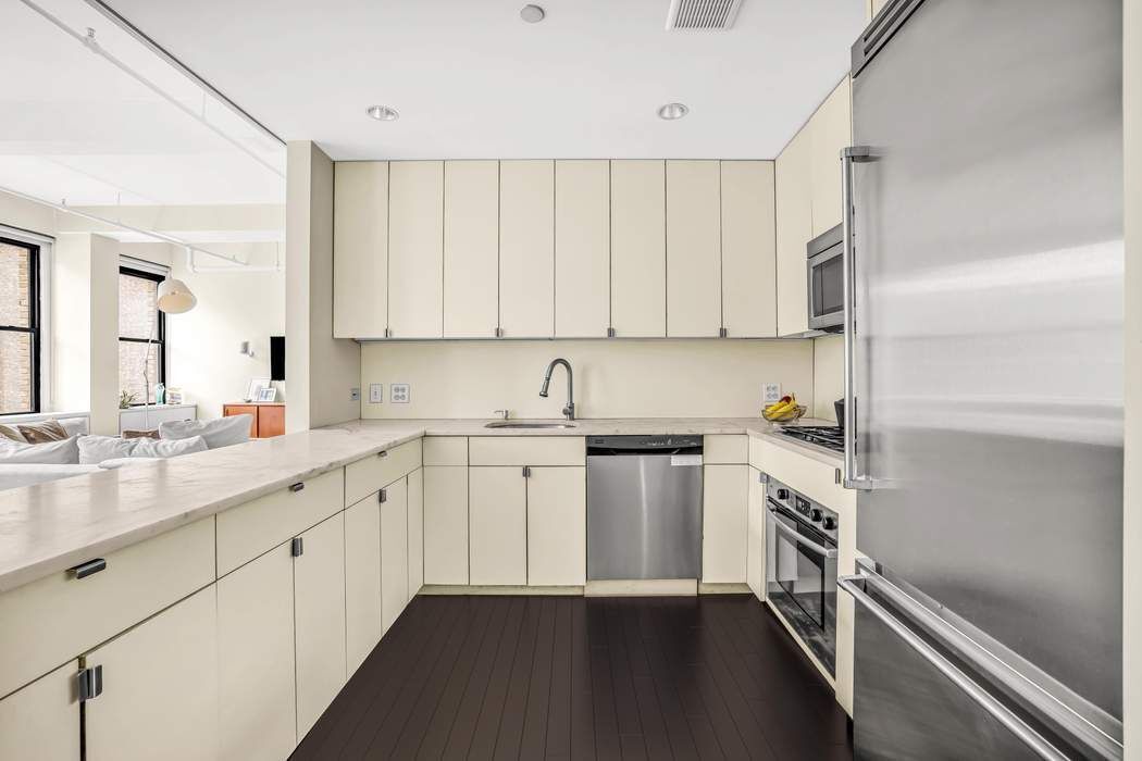 11 West 30th Street, Unit 8F Manhattan, NY 10001 - Photo 6 of 20 a kitchen with granite countertop white cabinets and white appliances