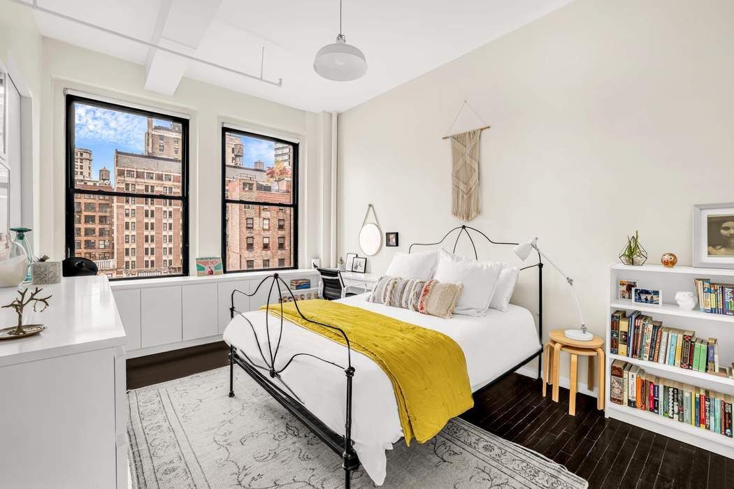 11 West 30th Street, Unit 8F Manhattan, NY 10001 - Photo 8 of 20 a bedroom with a bed a large window and book shelf