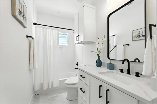 a bathroom with a granite countertop sink toilet and shower