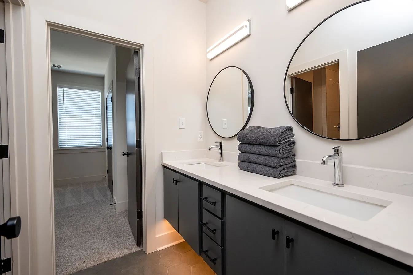 752 Meda Street Memphis, TN 38104 - Photo 12 of 18 Double vanity featuring integrated sinks, white countertops, and dark cabinetry with matte black hardware