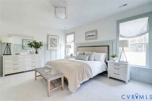 a spacious bedroom with a bed and a dresser