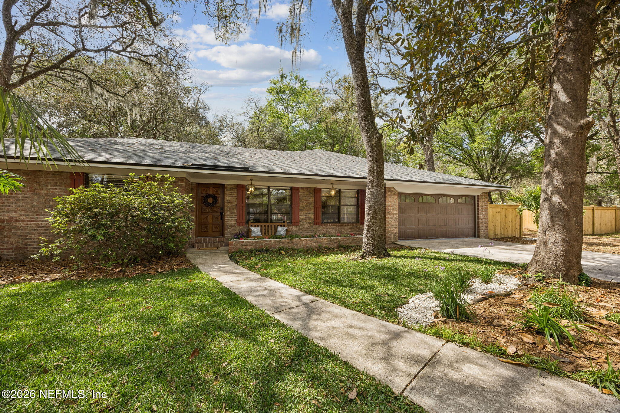 a front view of a house with a yard and shrubs