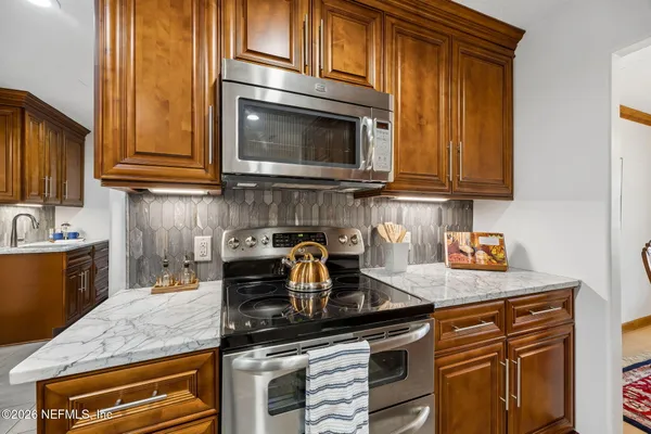 a kitchen with granite countertop a stove and a sink