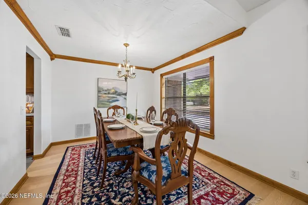 a view of a dining room with furniture and chandelier