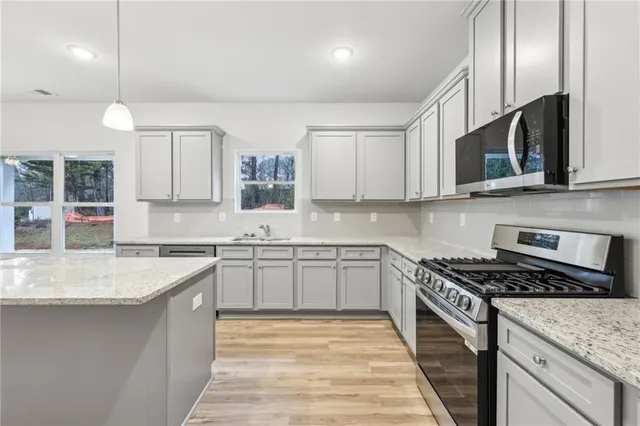a kitchen with stainless steel appliances granite countertop a sink stove and cabinets
