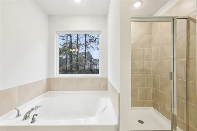 a white bath tub sitting next to a shower