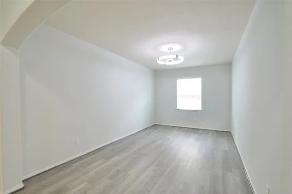 an empty room with wooden floor and a window
