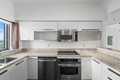 a kitchen with stainless steel appliances granite countertop a sink and a granite counter tops
