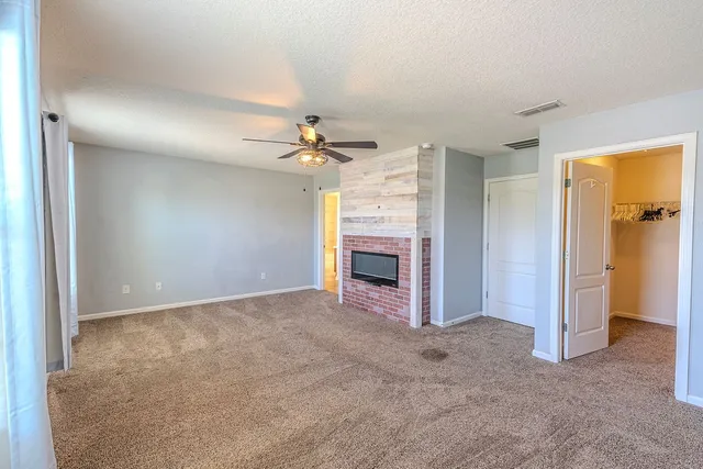 an empty room with a window and a fan