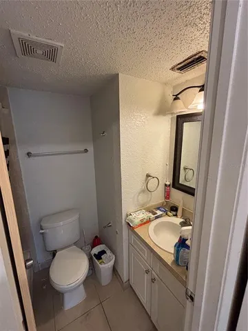 a bathroom with a granite countertop toilet sink and mirror