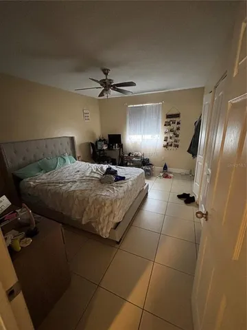 a spacious bedroom with a bed a chandelier and a window