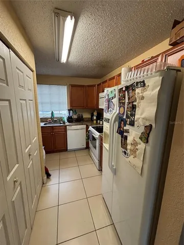 a kitchen with granite countertop a refrigerator and a stove top oven