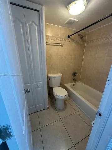 a bathroom with a granite countertop bathtub shower and toilet