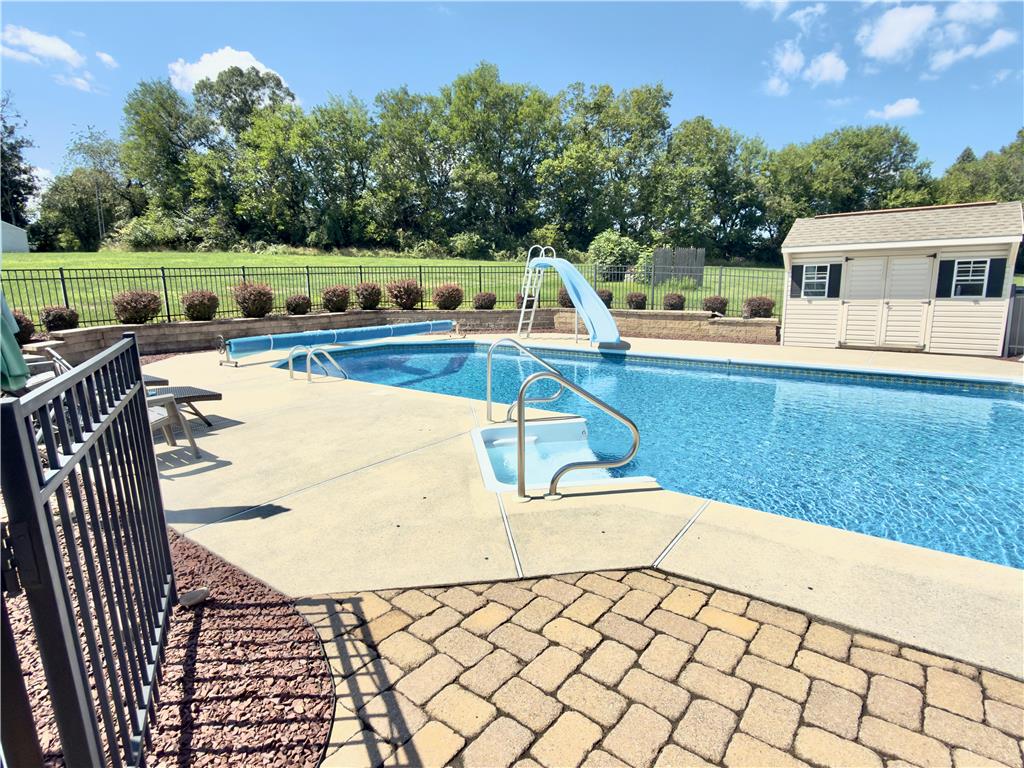 4982 Abbey Road Coplay, PA 18037 - Photo 51 of 55 An inviting backyard swimming pool is bordered by a concrete patio and brick pavers.