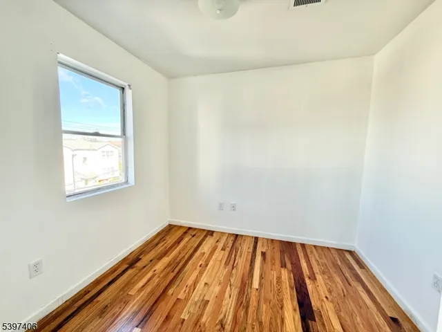 a view of a room with wooden floor and small window
