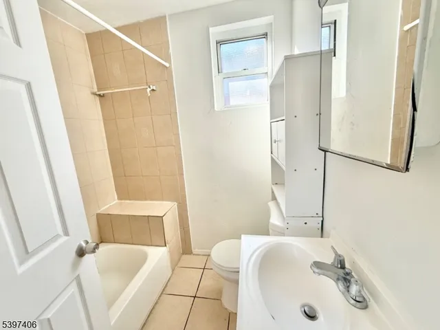 a bathroom with a tub sink and mirror
