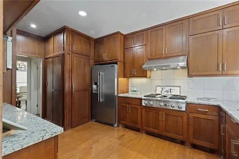 a kitchen with stainless steel appliances granite countertop a refrigerator and a sink
