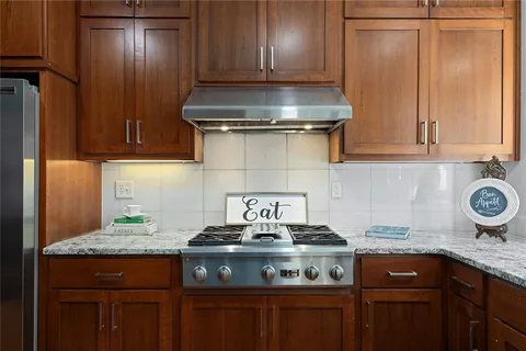 a kitchen with granite countertop stainless steel appliances stove and cabinets