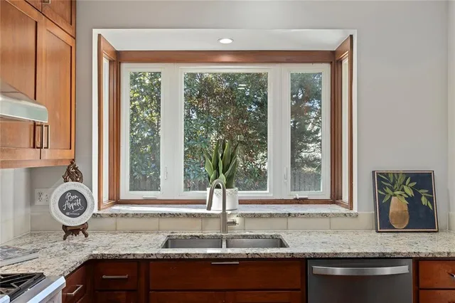 a kitchen with granite countertop a sink and a window