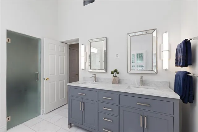 a bathroom with a granite countertop double vanity sink and mirror