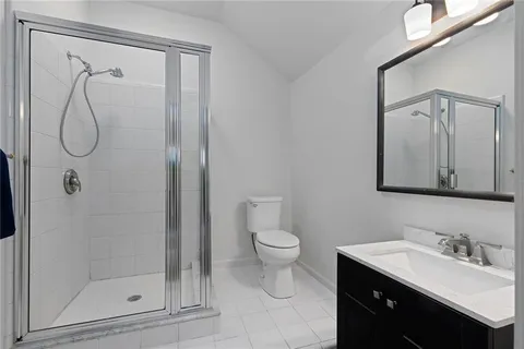 a bathroom with a granite countertop sink a toilet and shower