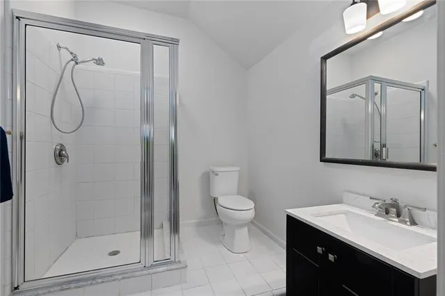 a bathroom with a granite countertop sink a toilet and shower