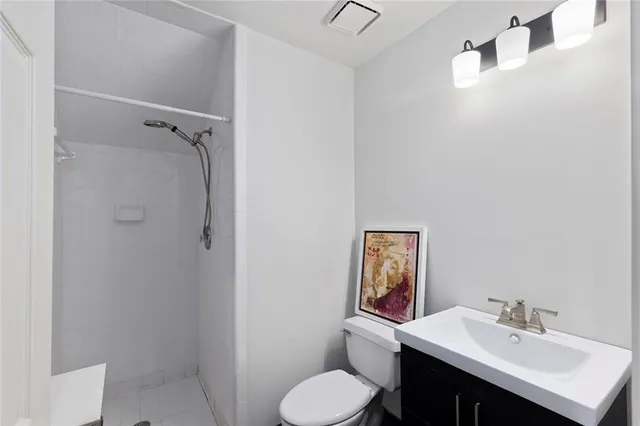 a bathroom with a toilet sink vanity and mirror