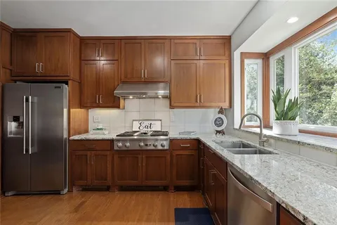 a kitchen with stainless steel appliances granite countertop a sink stove and refrigerator