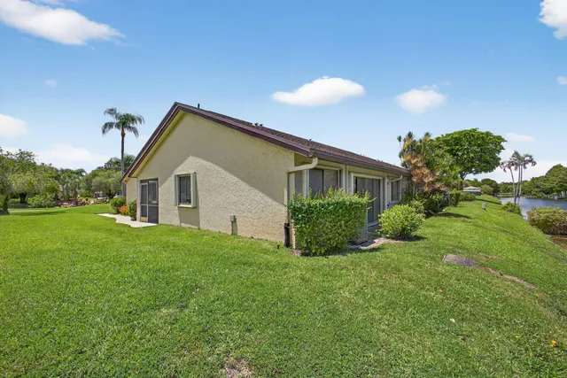 a view of a lake with a yard and a large tree