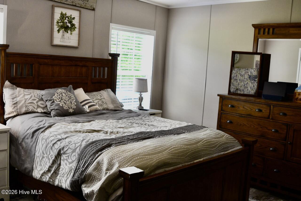 1430 Nixonton Road Elizabeth City, NC 27909 - Photo 16 of 30 The primary suite is also a spacious room. There is plenty of room for a queen size bed an a couple of dressers. There is a closet that goes the length of the room.
