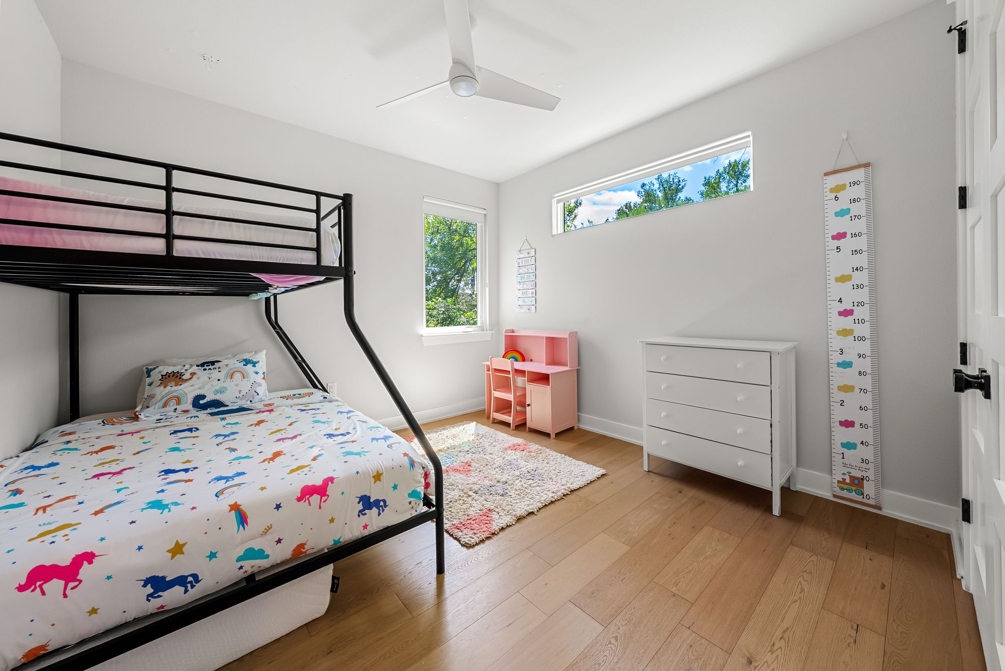 5109 Stone Gate Drive, Unit 1 Austin, TX 78721 - Photo 23 of 36 a bedroom with a bed and wooden floor