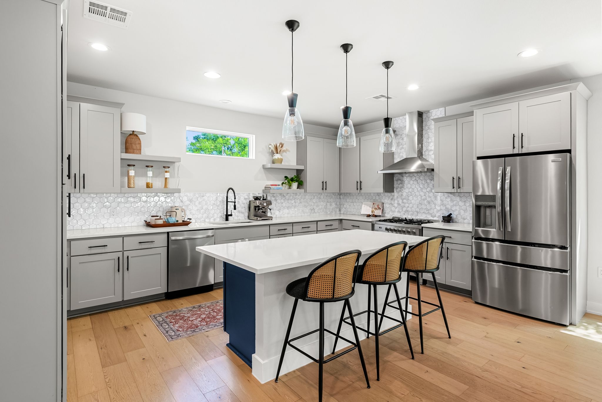 5109 Stone Gate Drive, Unit 1 Austin, TX 78721 - Photo 5 of 36 a kitchen with stainless steel appliances granite countertop a sink a stove a refrigerator and island with wooden floor