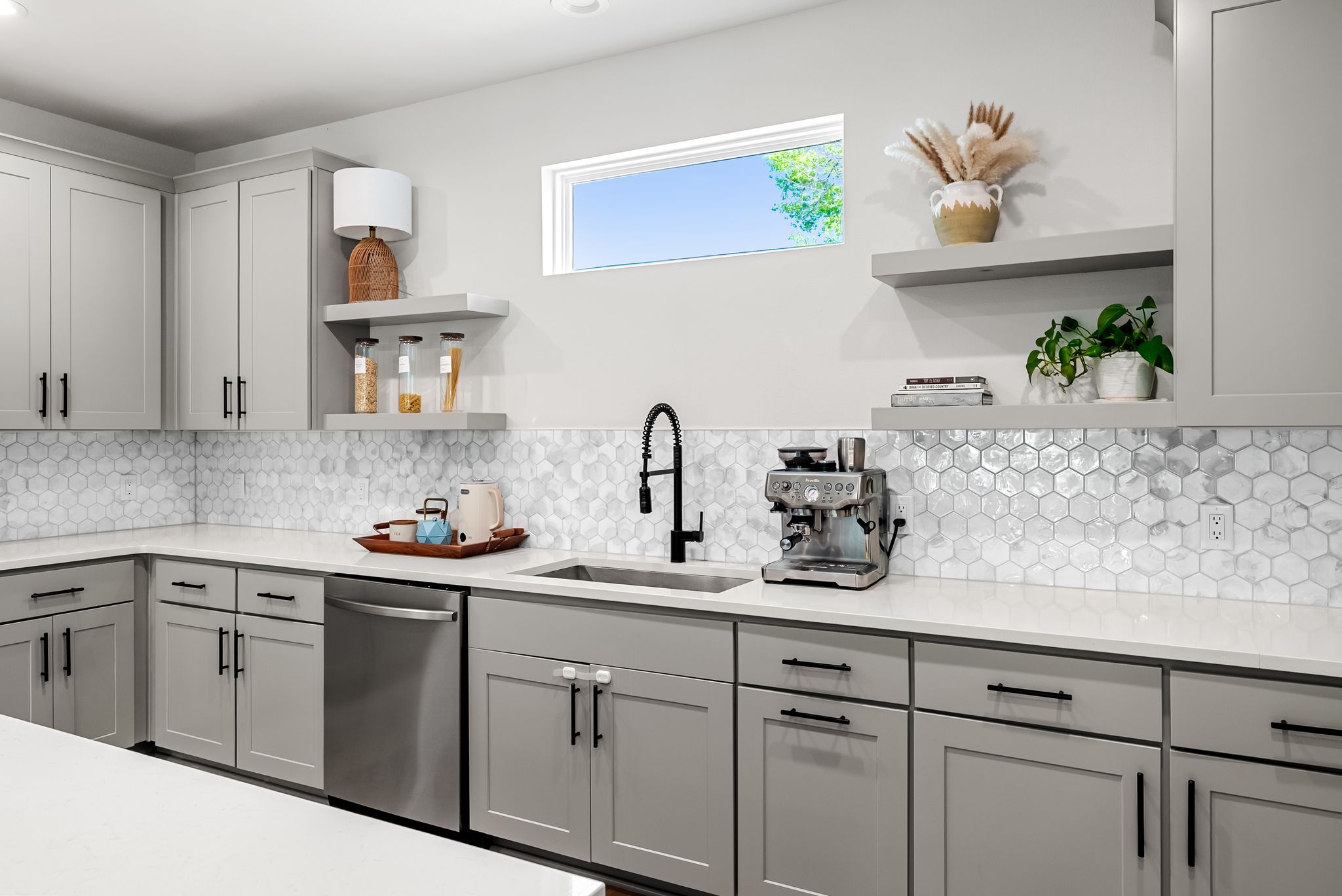 5109 Stone Gate Drive, Unit 1 Austin, TX 78721 - Photo 9 of 36 a kitchen with white cabinets a sink and dishwasher