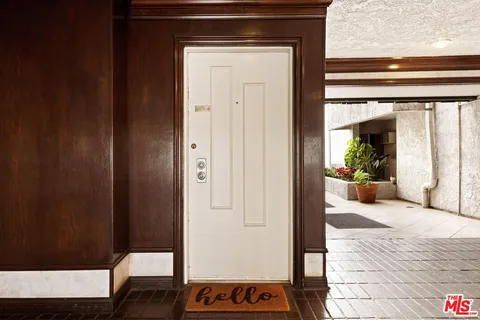 a view of a hallway with wooden floor and a livingroom