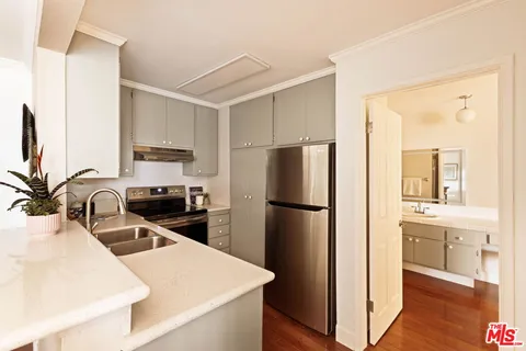 a kitchen with a refrigerator a sink a stove and cabinets