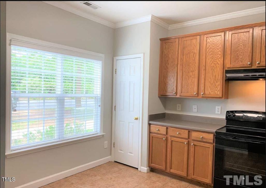 142 Forthview Way Apex, NC 27502 - Photo 3 of 11 a kitchen with wooden cabinets and a stove top oven