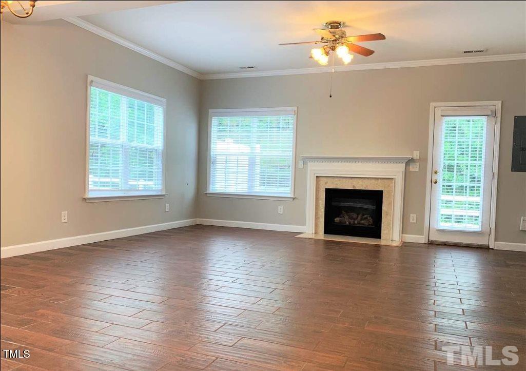 142 Forthview Way Apex, NC 27502 - Photo 4 of 11 an empty room with wooden floor fireplace and windows