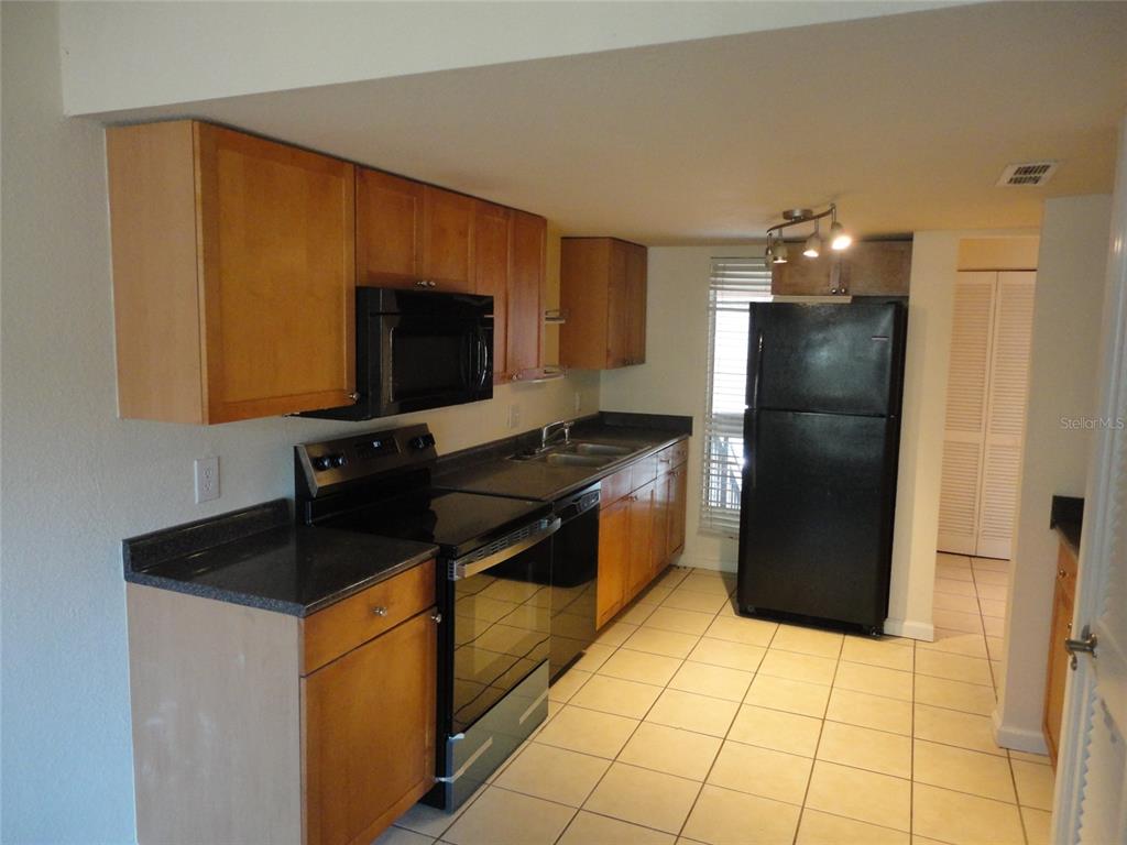 1810 Northwest 23rd Boulevard, Unit 207 Gainesville, FL 32605 - Photo 13 of 14 a kitchen with a refrigerator and a sink