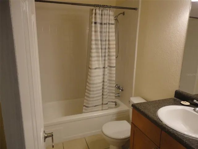 a bathroom with a granite countertop toilet sink and shower