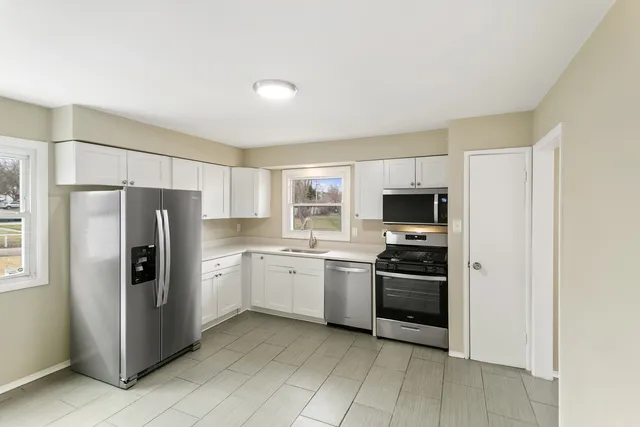 a kitchen with stainless steel appliances granite countertop a refrigerator and a stove top oven