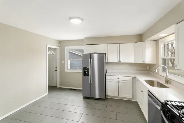 a kitchen with a sink a refrigerator and cabinets
