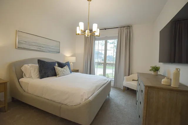 a living room with furniture kitchen view and large windows