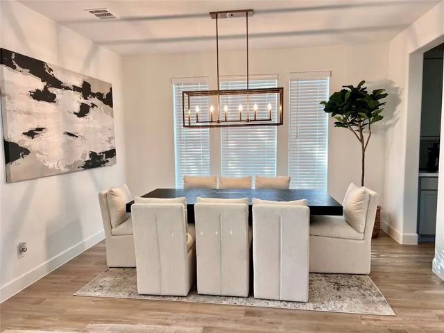 a kitchen with stainless steel appliances granite countertop a stove a sink dishwasher and a refrigerator with wooden floor