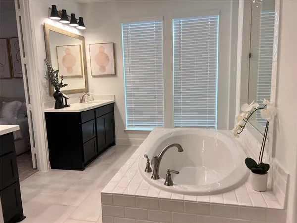 a bathroom with a tub sink and mirror